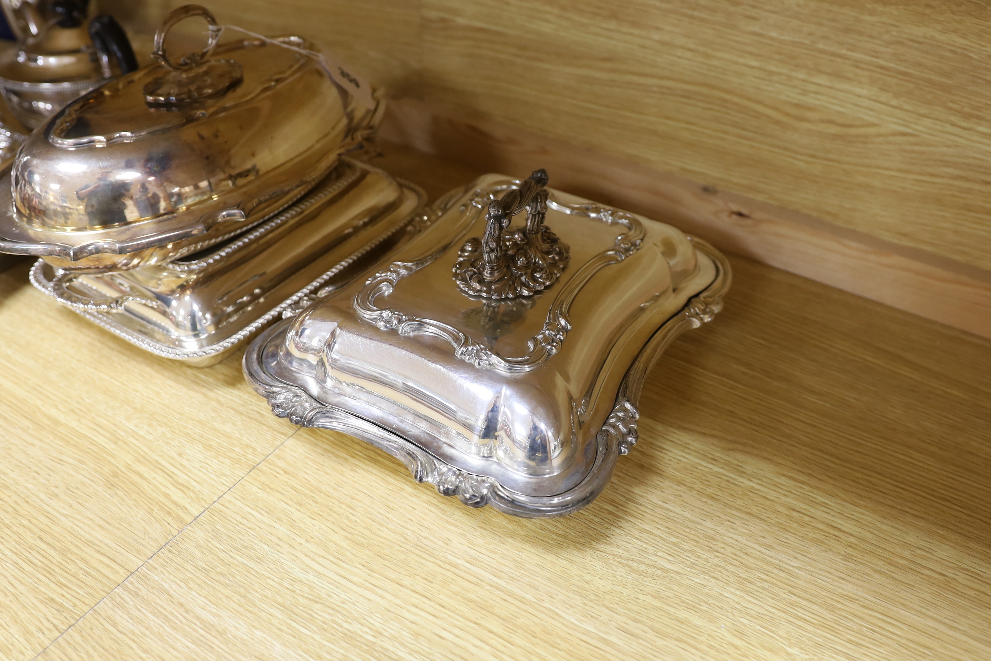 A quantity of silver plate including tea and coffee pots with ebonised handles and a pair of serving dishes